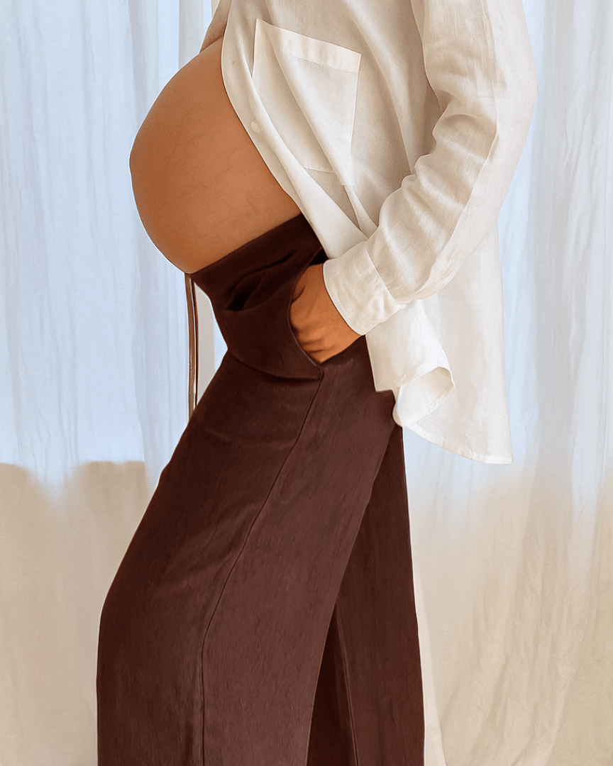 Person wearing a white shirt and brown pants with a blurred background